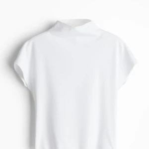 HELT NY! - HELT NY! Säljer en stilren vit halvpolotop. Den är ärmlös och har en hög krage som ger en elegant touch. Perfekt för både vardag och fest. Materialet känns mjukt och bekvämt mot huden. Passar L-XL