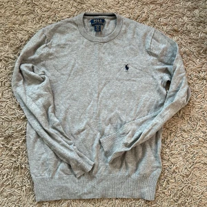 Grå Ralph Lauren Tröja - Jättefin och skön Ralph Lauren tröja. Skick 10/10, köpt för 500kr, säljer för 250kr. Storleken är S
