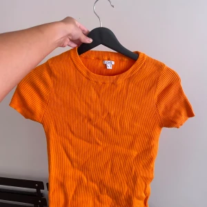 Orange t-shirt-topp - Skrynklig på bilden men fint skick! Inte nopprig eller så. Köpt second hand så osäker på märke