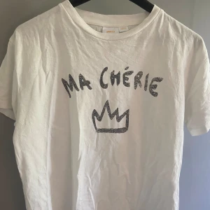 T-shirt med trycket ”MA CHÉRIE” från Ginatricot Young  - En jättefin t-shirt från Ginatricot Young i storlek 158/164. Den är sparsamt använd och i ett jättefint skick! 