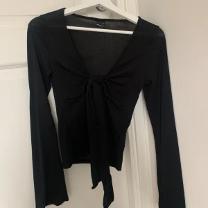 Svart topp  - Säljer denna populära svarta toppen från Gina som man knyter vid bröstet. Använd ca 3 ggr och nypris är 300kr 😊