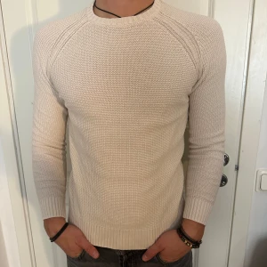 Beige stickad tröja - Säljer en snygg, stilren och bekväm beige stickad tröja i storlek S. Tröjan är långärmad och har en Slimmad passform. Modellen är 182 cm och väger 75 kg. Pris går att diskuteras!