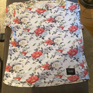 Vit blommig t-shirt - En vit blommig t-shirt i fint skick