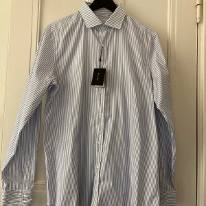 Ny Massimo dutti skjorta L - Vit blå randig Massimo dutti skjorta i storlek L . Ny endast testad, inga skavanker. Nypris 799kr, köp för endast 399.