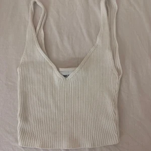Vit ribbad linnetopp - En vit ribbad linnetopp med smala axelband och v-ringad hals. Toppen är ärmlös och har en tight passform. Väldigt gullig, passar tyvärr inte längre så därför säljer jag. Nypris:300kr💓💓
