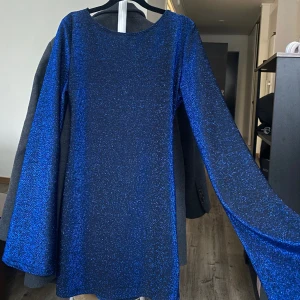 Glittrig klänning  - Glittrig klänning med öppen rygg, aldrig använd