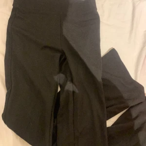 Svarta utsvängda byxor  - Svarta byxor utsvängda där nere