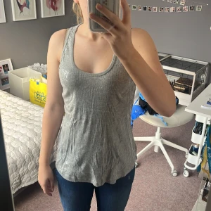 Fest topp - Grått silver glittrigt linne från Style Butler. Säljer då jag aldrig använder det. Bra skick men funnits med många år. Storlek 38 men passar allt från Xs-M beroende på hur man vill att det sitter❤️