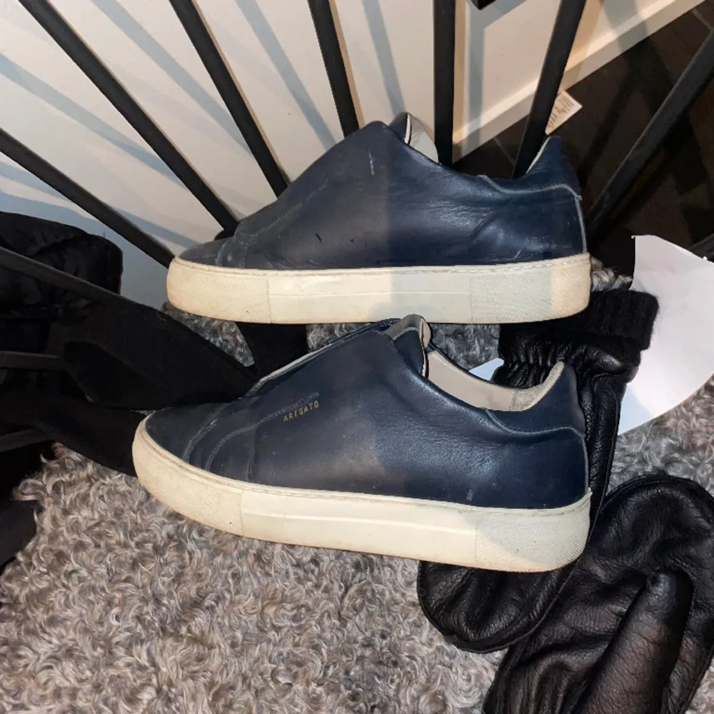 Arigato Clean 360 Laceless Sneaker. Mörkblå färg. Finns tydliga tecken på användning men dom har mer att ge. Hör av er vid frågor. Storleken är 40 men dom sitter som 41.. Skor.