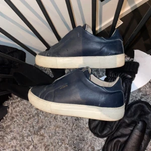 Arigato Skor Laceless - Arigato Clean 360 Laceless Sneaker. Mörkblå färg. Finns tydliga tecken på användning men dom har mer att ge. Hör av er vid frågor. Storleken är 40 men dom sitter som 41.