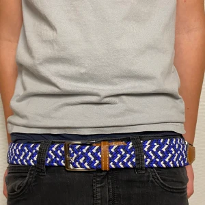 Grisch/Flätat Bälte - Säljer ett grisch/flätat bälte i färgerna blå, vit samt svart. Bältet är 110 vem långt men är stretchig så kan lätt anpassas till större storlek | Skick: 10/10 (aldrig använd). | Hör av er vid frågor och funderingar!