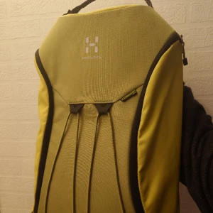 Grön Haglöfs ryggsäck ovanlig limegrön färg med öppning på sidan i bra skick - En Haglöfs ryggsäck med någon liten fläck men i jättebra skick i stort. Jag har inte tvättas den än. Öppnas längs med sidan, bra lönnfack upptill för nycklar/pengar, bra fack inuti för vattenflaska. I limegrön, finns nog inte längre att köpa.