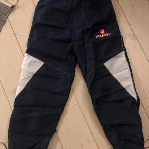 Säljer ett par Fubu trackpants.  De har en liten reva i sig vid slutet av ett av benen. Annars i fint skick (Kan skicka bild om du är intresserad) Passformen är baggy/loose fit PS! Skriv till mig om du är intresserad 