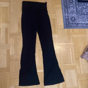 Svarta utsvängda yoga pants  - Svarta utsvängda yoga pants man viker ner 