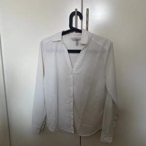 En vit v-ringad skjorta från H&M i storlek S. 