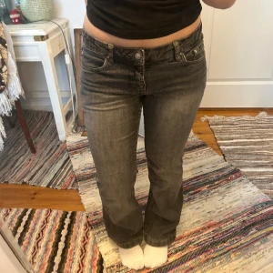 Low waist jeans - Gråa lågmidjade jeans med rinestones på fickorna. Bra skick. Det står st.38, men jag skulle snarare säga 34/36. Från ett märke som heter tuttifrutti. 