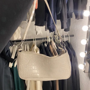 väska - glansig, vit axelväska med krokodilmönster. kort band✅