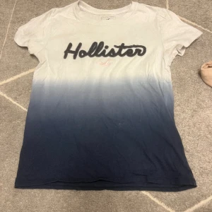 Hollister t-shirt - Tshirt från hollister , äkta naturligtvis. Har en liten fläck som man ser på tredje bilden, men i helhet synd det ej sp mycket eftersom det bländas in med färgen.