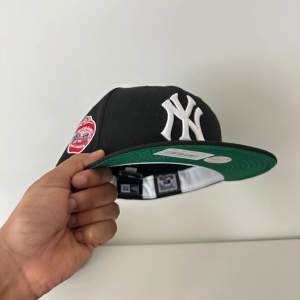 New York Yankees. Brand new with original packaging. Black with Green brim. Size 7 5/8. 