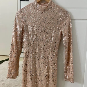 Paljettklänning från Ginatricot  - En helt ny paljettklänning från Ginatricot i färgen nuderosa. Klänningen är figursydd och sitter väldigt fint på. Storlek xs 