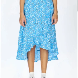 Blå kjol med blommor - Säljer eftersom jag inte använder den längre 💕 Kjolen är i mycket bra skick, har nästan aldrig haft på mig den. Nypris 299kr