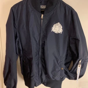 Pripps Blå Bomberjacka  - Pripps Blå Bomberjacka i storlek L, inte använd många gånger och som ny. 
