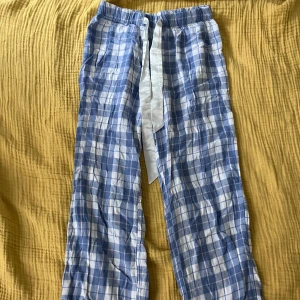 Rutiga pyjamasbyxor - Blå/vit/rosa rutiga pyjamasbyxor. Jätteliten fläck på benet (bild 2), försvinner nog i tvätten. 