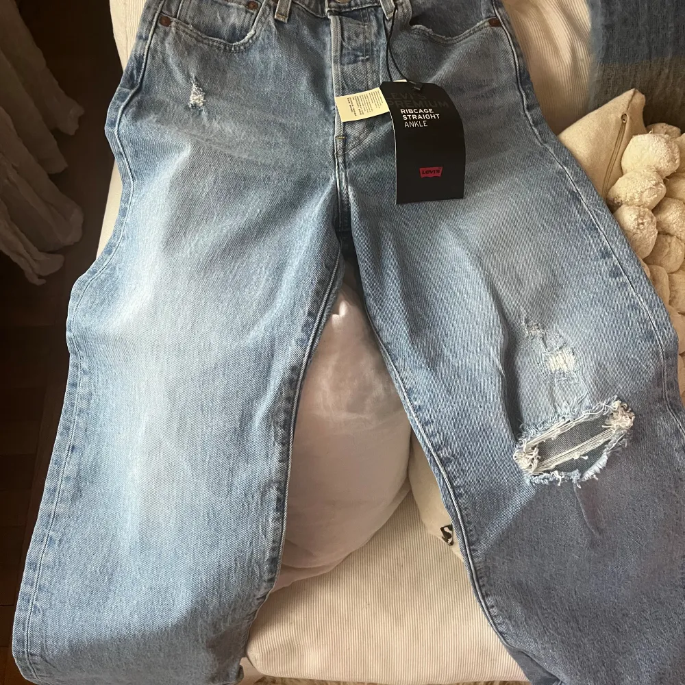 Helt oanvända jeans från Levi’s i storlek 26x27. Jättefina på men ej blivit använda. Hög midja, croppade ben och reva på ena knät.. Jeans & Byxor.