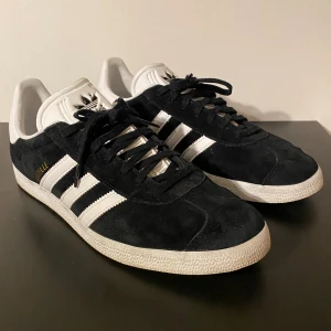 Adidas Gazelle stl 45 - Jag säljer ett par svarta Adidas Gazelle i storleken 45. De är sparsamt använda och är perfekta nu till våren och ett måste att ha i garderoben! Kartong samt vita snören medföljer. Hör av er vid frågor// Alwe