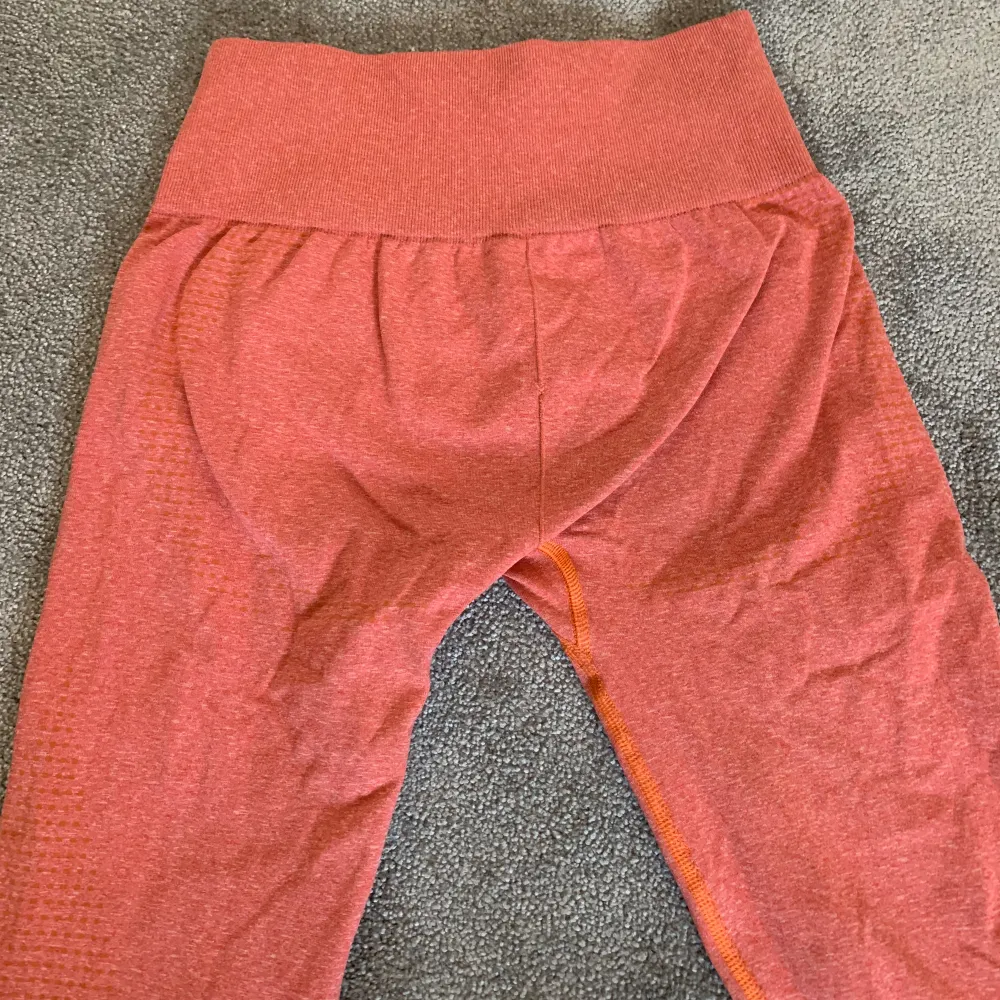 Säljer dessa orangea gymshark byxorna då de är lite små för mig 🤍 de har ett litet hål på rumpan (se sista bilden) kom priv för bättre bilder 🤍 passar mig i längden som är ca 155 cm! 🤍🤍. Jeans & Byxor.