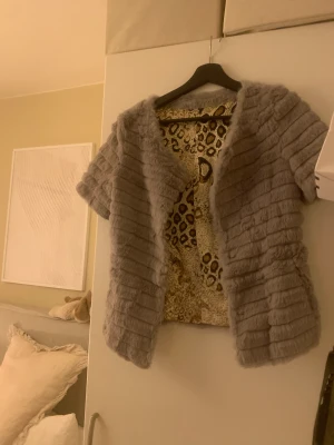 Kort ärmad päls kofta/jacka - En kort ärmad/trekvart ärmad kofta/jacka. Mönstret syns ej när den är på. Jätte fin bara inte fått till användning. 