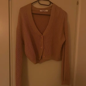 Stickad kofta  - En stickad kofta som är ganska kort i modellen. I mycket gott skick och har använts fåtal gånger.