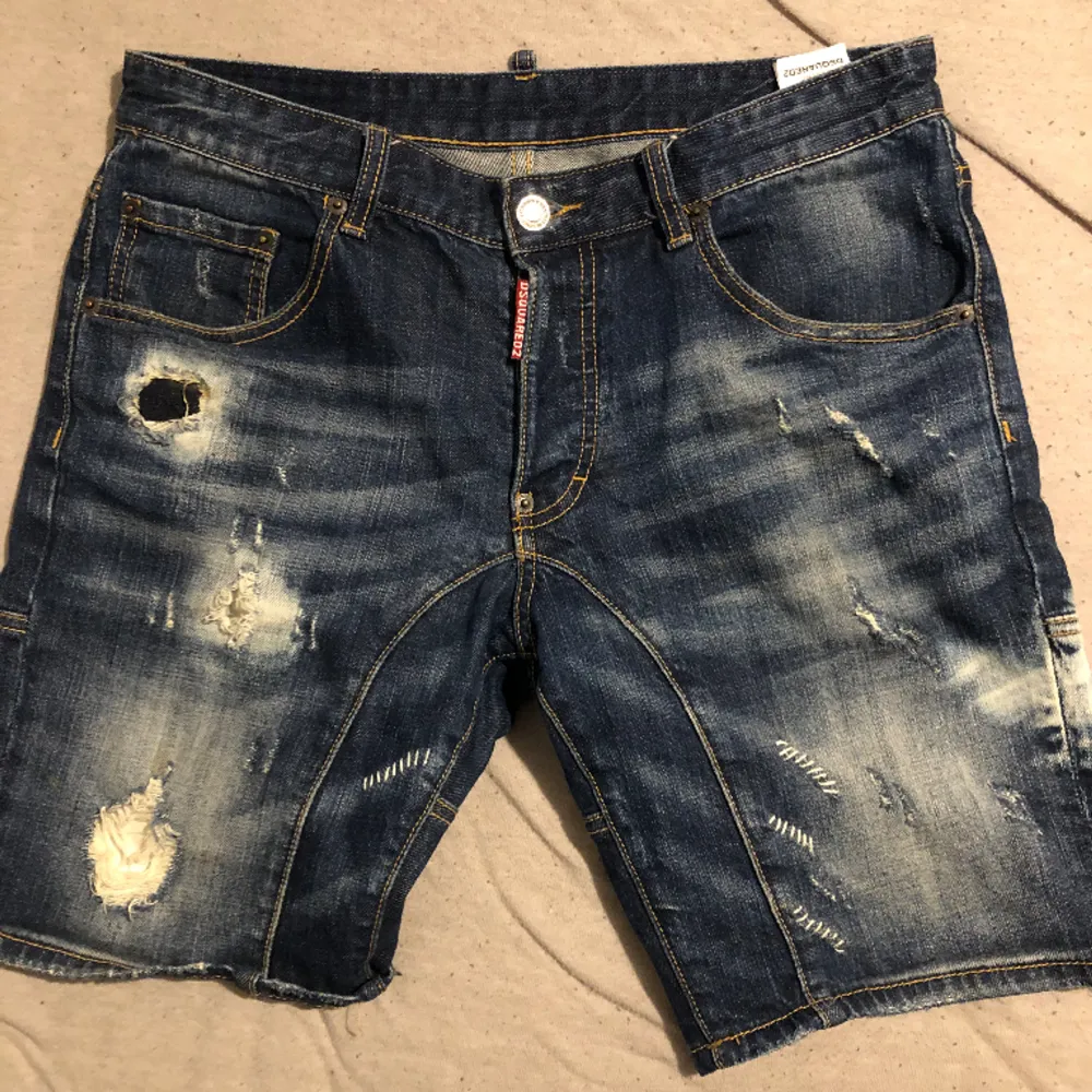 Blåa Dsquared2 jeans shorts. Snygga till sommaren som snart är här, säljer de pågrund av att de är för små. Det finns lite defekter som ni kan se på bilden där trådarna har lossnat vid hålet och därför säljer jag för billigt pris.. Shorts.