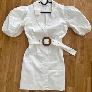 Skjortklänning - Kort klänning med puff-ärmar och skärp. Sjukt snygg men är tyvärr för liten för mig… använd 2ggr så i mycket fint skick! Hade varit en otroligt fin studentklänning. Skriv till mig så kan jag skicka mått på klänningen