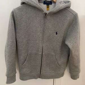 En grå Ralph Lauren zip hoodie i junior storlek som är i bra skick. Storlek 10-12 år (146cm) 