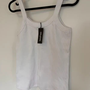 Vitt linne - Oanvänd, med lappen kvar! Vitt ribbat linne med lite tjockare band och kant ✨ Priset är förhandlingsbart!