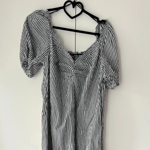 Svartvit rutig jumpsuit  - En svartvit rutig jumpsuit med sweetheart ringning från Monki. Suppergullig men kommer tyvärr inte till användning mer.   Resår i ryggen, ärmarna och vid ringningen. Dragkedja i sidan (bild 3)  Endast använd en gång. Normal i storleken. 