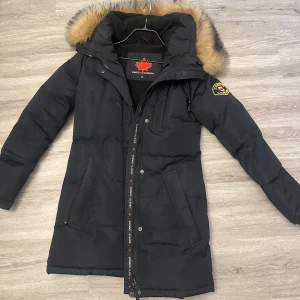 Vinterjacka - Vinterjacka med pälskrage, storlek XS kan passa en liten S. Betydligt varmare än min canada goose. Lång till över knäna ungefär beroende längd jag är 164cm. Som ny 