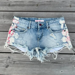 Jeansshorts  - Lågmidjade jeansshorts i ljusblått. Midjemåttet tvärs över är 36 cm. Skicket är mycket bra och de ser knappt använda ut