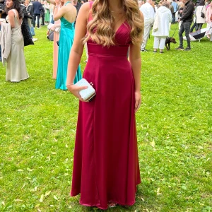 Mörkröd balklänning  - Köpt i usa och är i stl 4, motsvarande S. Silkestyg, slits vid sidan och v-ringad. Använd en gång i några timmar så är i gott skick. Hör gärna av er vid frågor