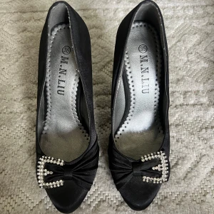 Svarta pumps men detaljer  - Jätte söta svarta klackar. Inköpta på loppis för något år sedan men aldrig använda av mig. Lossnat några diamanter framtill men inget man tänker på. 