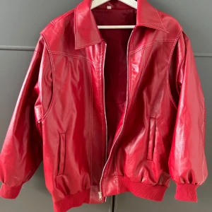 Superfin och cool röd läderjacka - Hej! Säljer min röda läderjacka som köptes några månader sen från märket ThinkBig&Co (Original pris 980kr). Helt oanvänd och i perfekt skick. Storleken är oversize för en mer avslappnad look. Väldigt fin och perfekt att stylea outfiten ❣️
