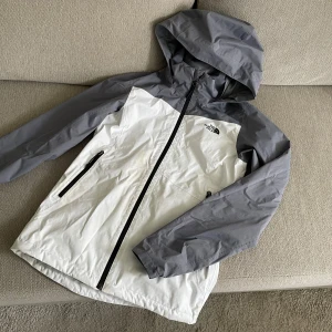 Grå vit the north face vind jacka - Super fin, har en fläck på framsidan där av priset. 
