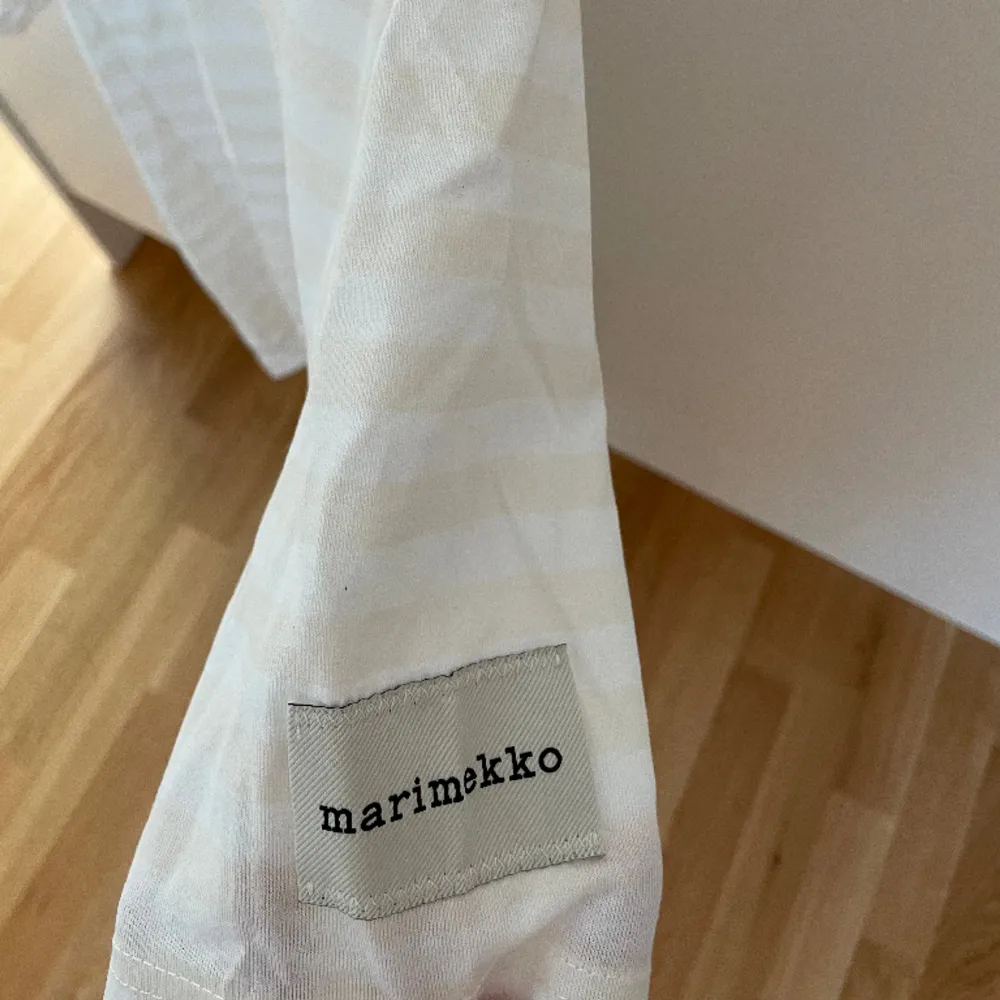 Vit- och beigerandig t-shirt från Marimekko. T-shirts.