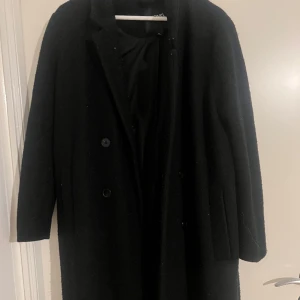 Monki svart rak kappa - Passformen är väldigt rak. Varm 