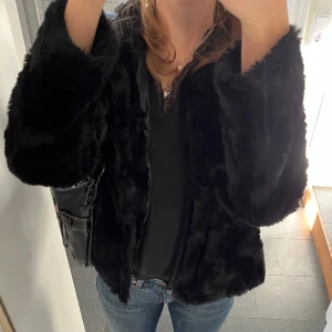 Svart pälsjacka från Vero Moda - Svart jacka från Vero Moda i fuskpäls. Storlek M. Fint skick. Säljer flera svarta pälsjackor och en exakt likadan som denna fast billigare då den är lite mer använd. Använd gärna köp nu!