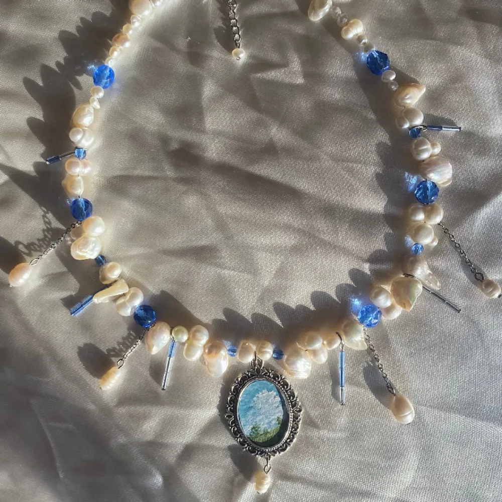 Halsband gjort av glaspärlor och sötvattenspärlor, med en berlock jag målat☁️💙 reglerbar längd 40-45cm Kika in min instagram @flyingladybugz för mer smycken💗🐞. Accessoarer.