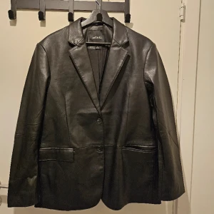 Jacka/kavaj från Monki - En oversized kavaj-jacka i läderimitation från Monki, storlek S, har små axelvaddar! Har aldrig använt den så den är i nyskick. 