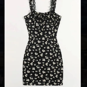 Klänning  - Svart känning med blommor, rosett ifram med volang band Storlek S Använd fåtal gånger 