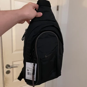Nike ESSENTIALS Sling Bag - Intressekoll på Nike Essentialls slingbag som är oanvänd/nyskick.